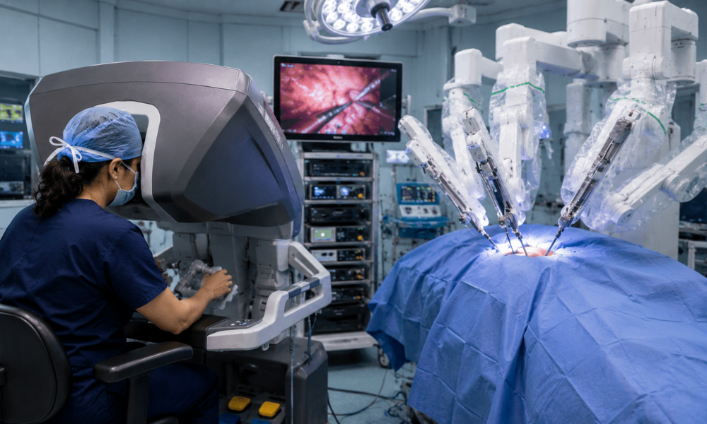 Surgeon operating a robotic surgical system during a minimally invasive cancer treatment procedure.